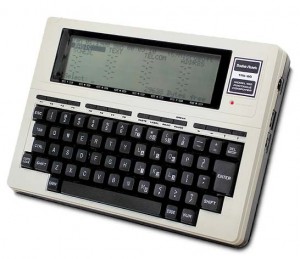 A vintage portable electronic typewriter with a built-in LCD screen and a QWERTY keyboard.